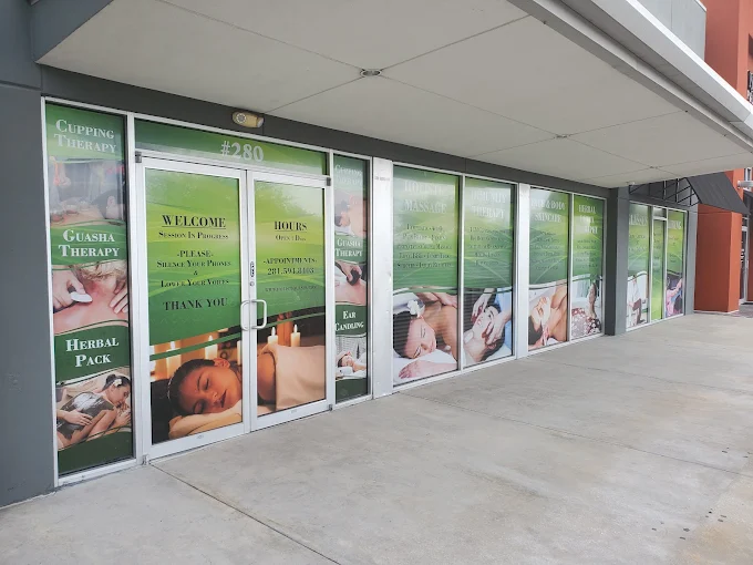Storefront of Holistique Healing Spa in Katy, TX with AcuQi and lymphatic massage signage on the windows.